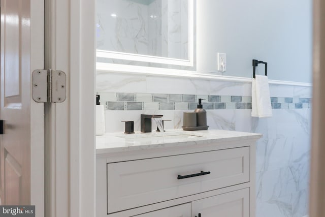 bathroom with vanity and tile walls