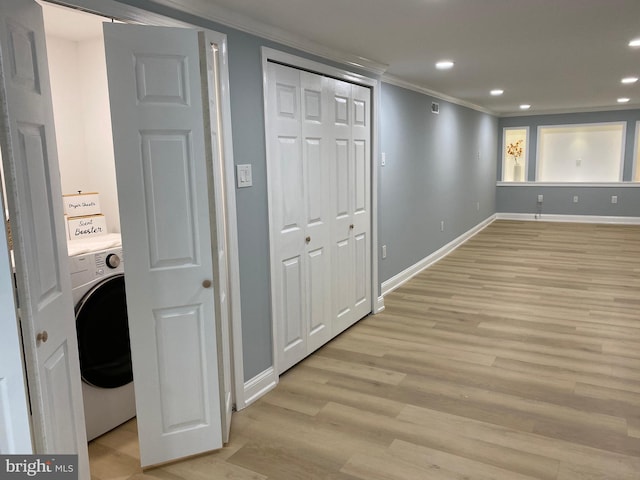 clothes washing area with washer / dryer, crown molding, and light hardwood / wood-style floors