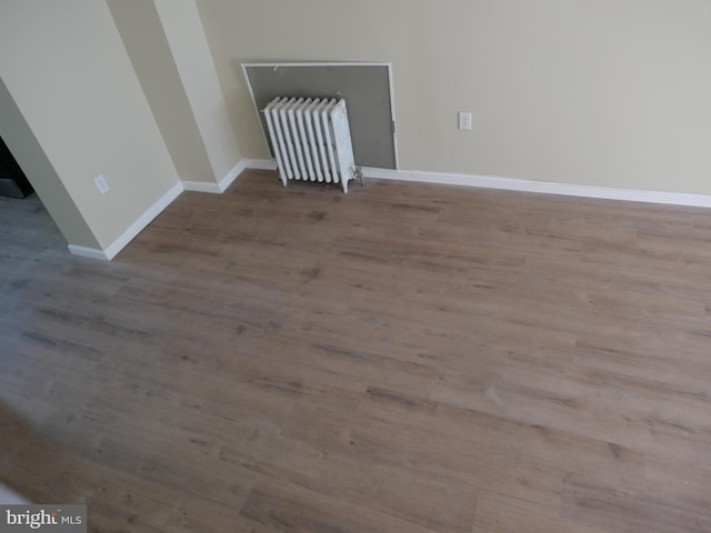 spare room featuring light wood-type flooring and radiator