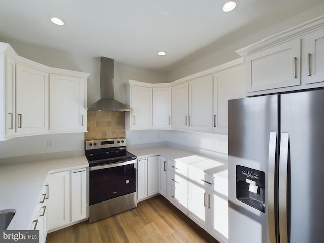 kitchen featuring white cabinetry, appliances with stainless steel finishes, and wall chimney range hood