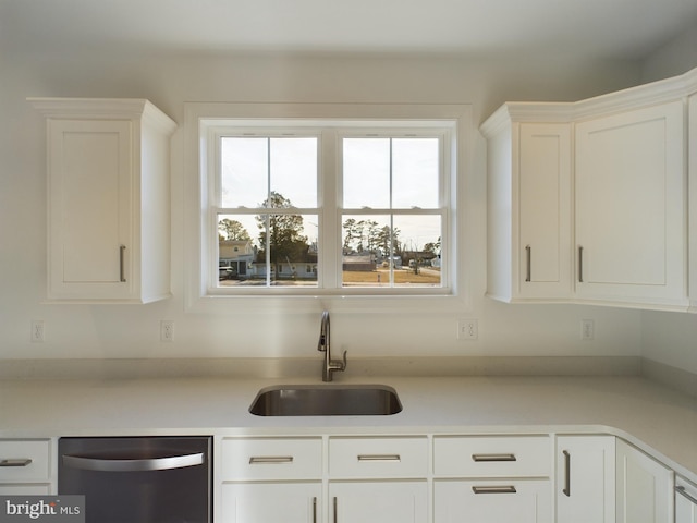 kitchen featuring dishwasher, white cabinetry, and sink