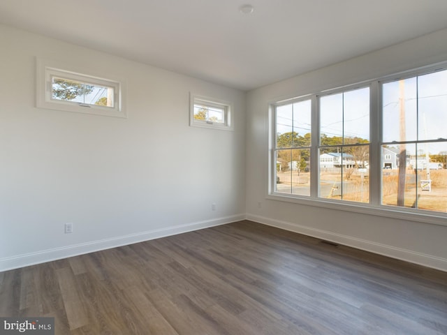 unfurnished room with a healthy amount of sunlight and dark hardwood / wood-style floors