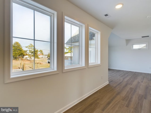 additional living space with dark hardwood / wood-style flooring