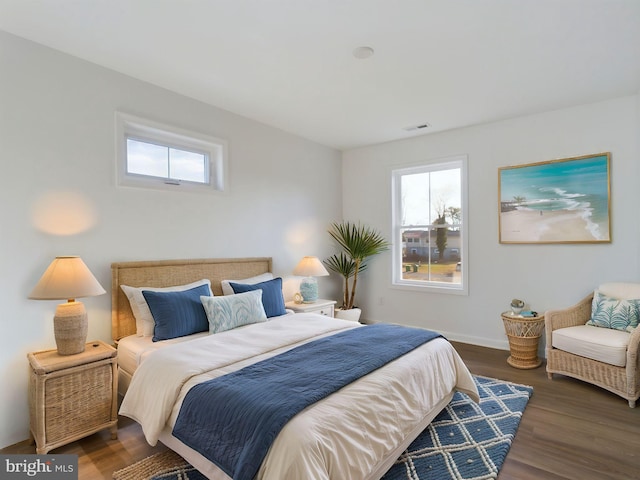 bedroom with multiple windows and dark hardwood / wood-style flooring