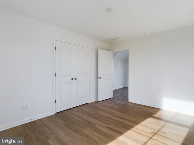 unfurnished bedroom featuring hardwood / wood-style floors and a closet