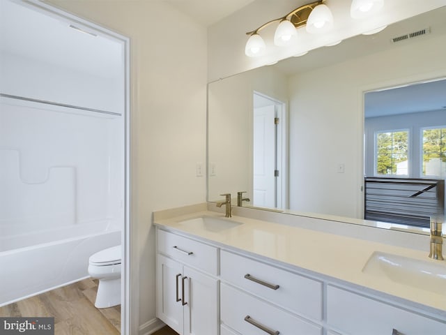 bathroom featuring vanity, hardwood / wood-style flooring, and toilet