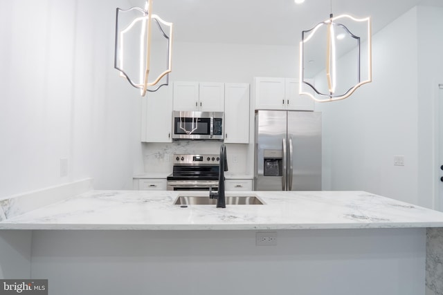 kitchen with stainless steel appliances, light stone counters, white cabinets, kitchen peninsula, and sink