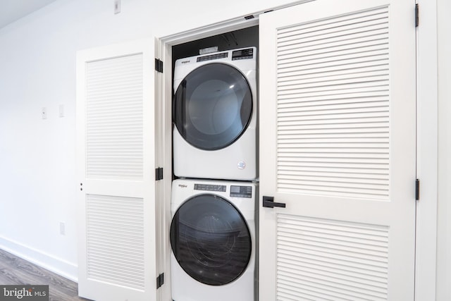 laundry room with stacked washer / drying machine and hardwood / wood-style floors