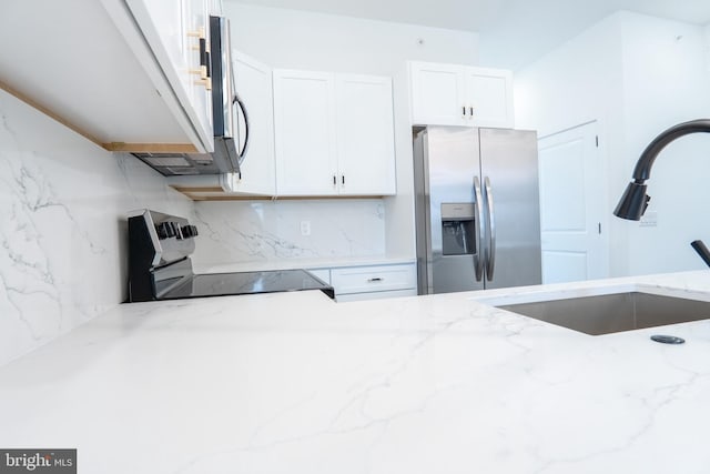 kitchen with stainless steel refrigerator with ice dispenser, black stove, sink, and light stone counters