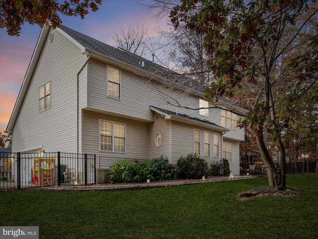 property exterior at dusk with a yard