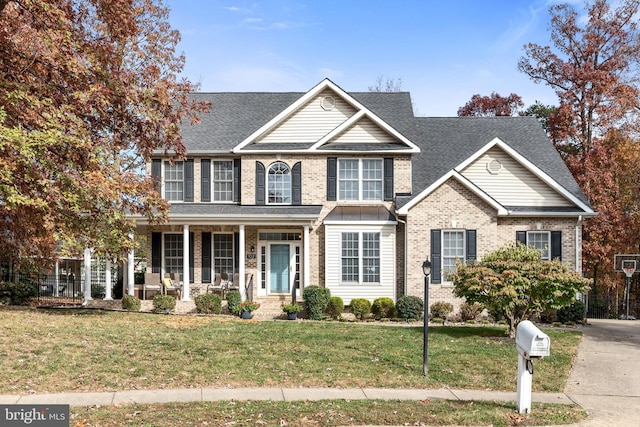 view of front of property featuring covered porch and a front yard