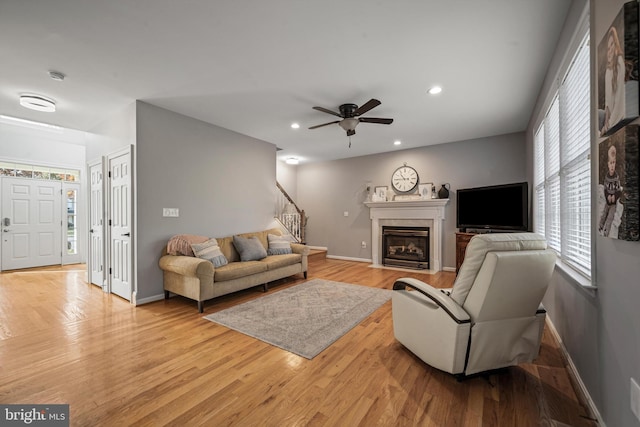 living room featuring light hardwood / wood-style flooring and ceiling fan