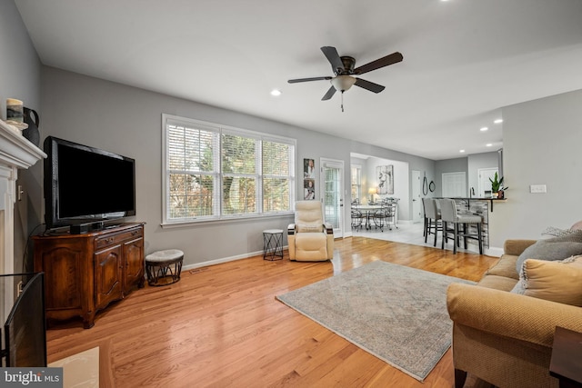 living room featuring ceiling fan and light hardwood / wood-style floors