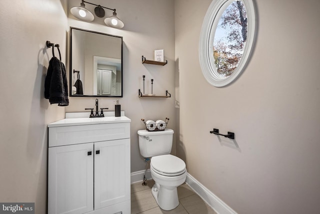 bathroom featuring toilet, vanity, and tile patterned flooring