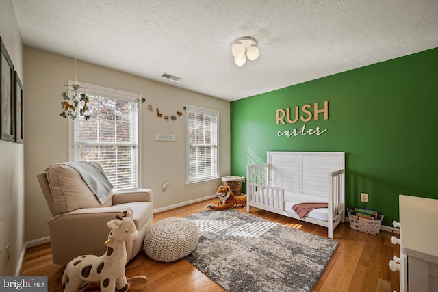 living area with wood-type flooring and a textured ceiling