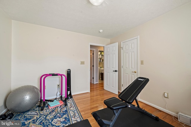 exercise area featuring a textured ceiling and hardwood / wood-style flooring