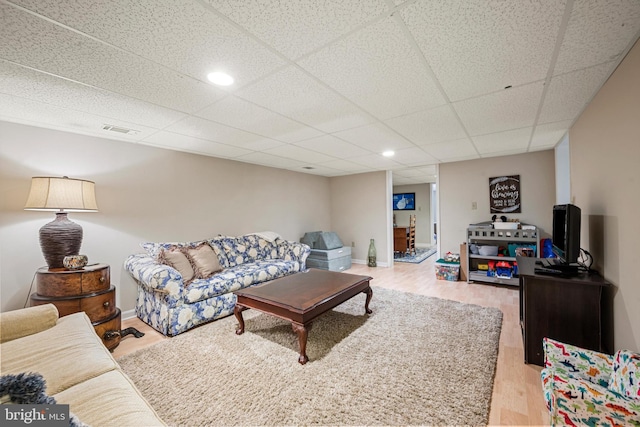 living room with a drop ceiling and hardwood / wood-style floors