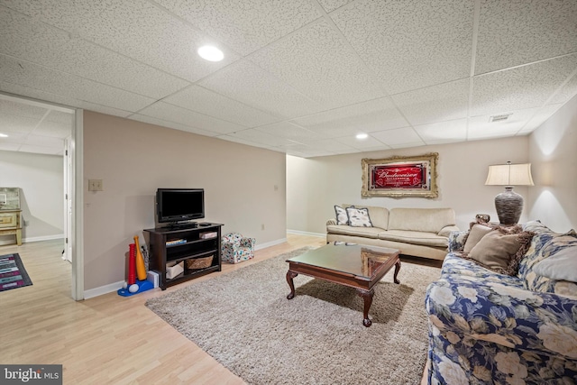 living room featuring hardwood / wood-style flooring and a drop ceiling