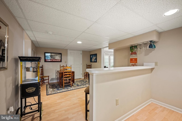 bar with hardwood / wood-style floors and a paneled ceiling