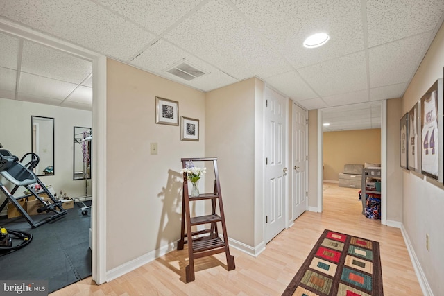 hallway featuring hardwood / wood-style flooring and a drop ceiling