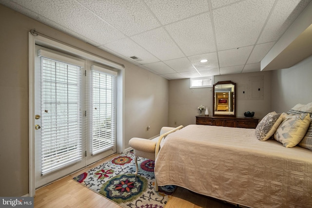 bedroom featuring wood-type flooring and a drop ceiling