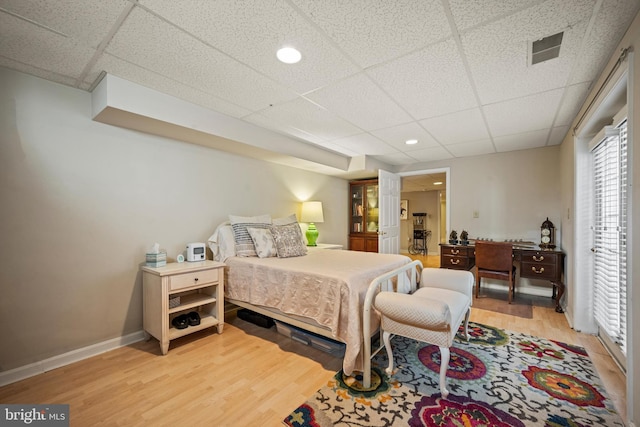 bedroom featuring a drop ceiling and hardwood / wood-style flooring