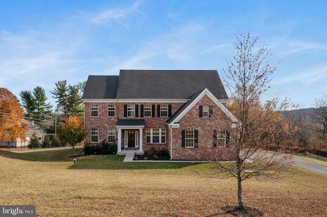 colonial inspired home with a front lawn