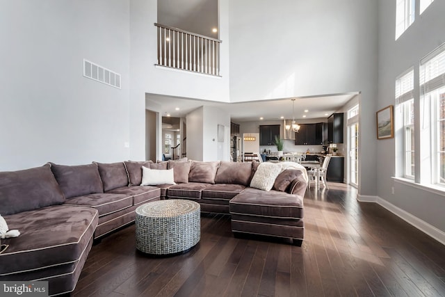 living room featuring dark hardwood / wood-style flooring and a towering ceiling