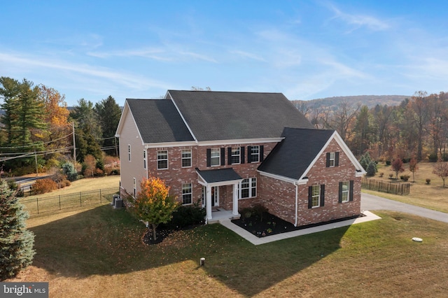 view of front of house featuring cooling unit and a front yard