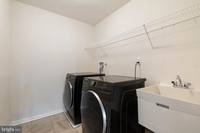 laundry area featuring sink, light tile patterned floors, and separate washer and dryer