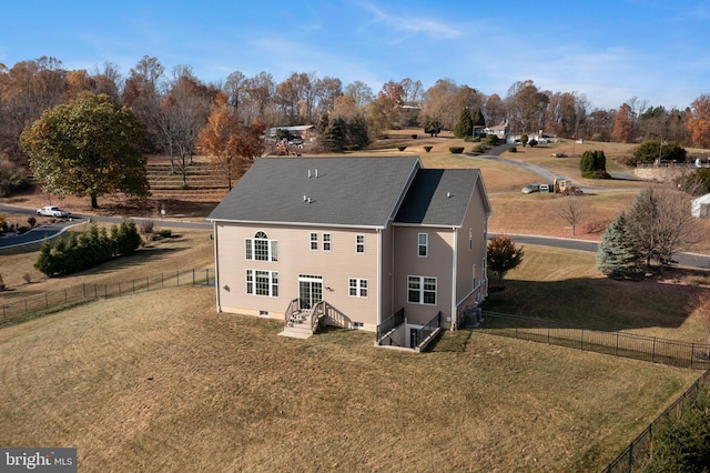 rear view of house featuring central AC and a yard