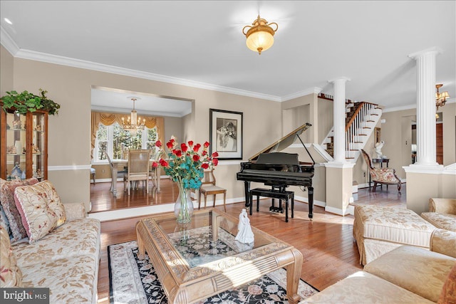 living room featuring ornate columns, light hardwood / wood-style flooring, and crown molding