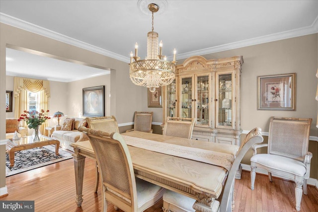 dining room featuring an inviting chandelier, wood-type flooring, and crown molding