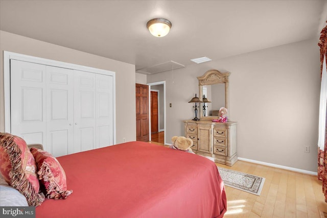 bedroom with light hardwood / wood-style floors and a closet