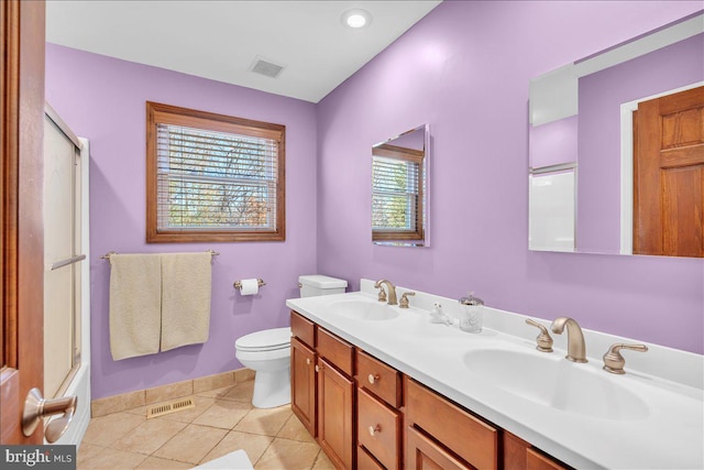 full bathroom featuring toilet, bath / shower combo with glass door, vanity, and tile patterned floors