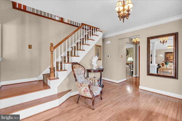 foyer entrance featuring wood-type flooring, crown molding, and a notable chandelier