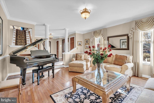 living room with ornate columns, hardwood / wood-style floors, and crown molding