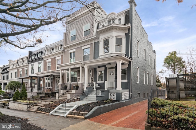 townhome / multi-family property featuring covered porch