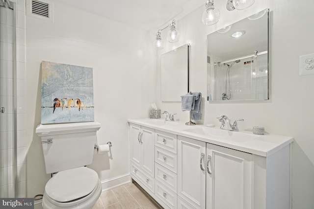 bathroom with a shower with door, vanity, and toilet