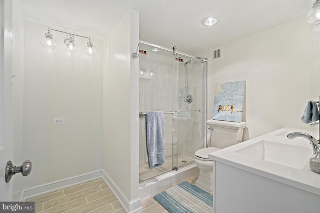 bathroom featuring vanity, toilet, and walk in shower