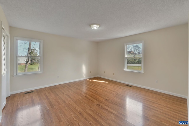 unfurnished room featuring wood-type flooring and a textured ceiling