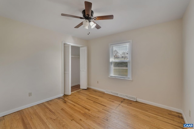 unfurnished bedroom featuring light hardwood / wood-style floors, ceiling fan, and a closet