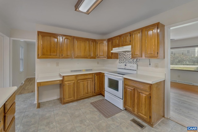 kitchen with light hardwood / wood-style floors, tasteful backsplash, and white range with electric cooktop