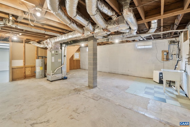 basement featuring electric water heater, sink, and heating unit