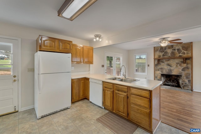 kitchen with kitchen peninsula, sink, ceiling fan, light hardwood / wood-style flooring, and white appliances