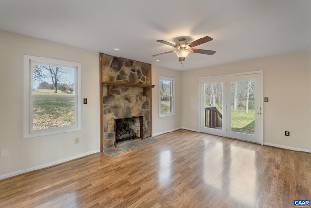 unfurnished living room with hardwood / wood-style flooring, ceiling fan, and a fireplace