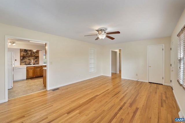 unfurnished bedroom with sink, ceiling fan, light hardwood / wood-style flooring, connected bathroom, and white refrigerator