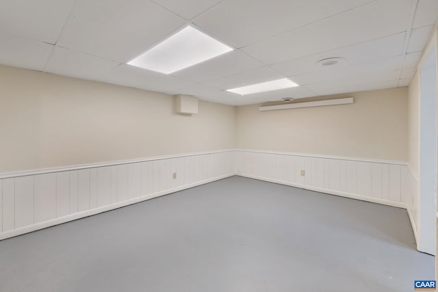 empty room with concrete flooring and a paneled ceiling