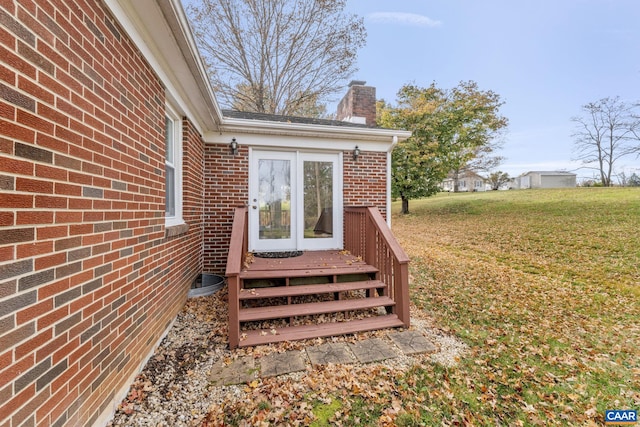 doorway to property featuring a lawn and a deck