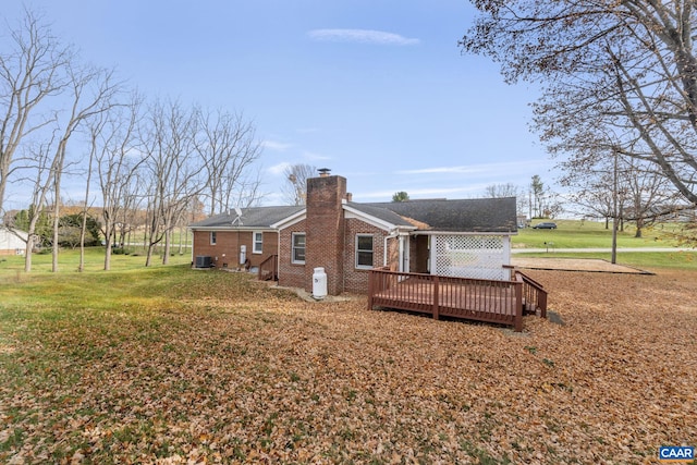 rear view of property featuring a deck, central AC unit, and a yard